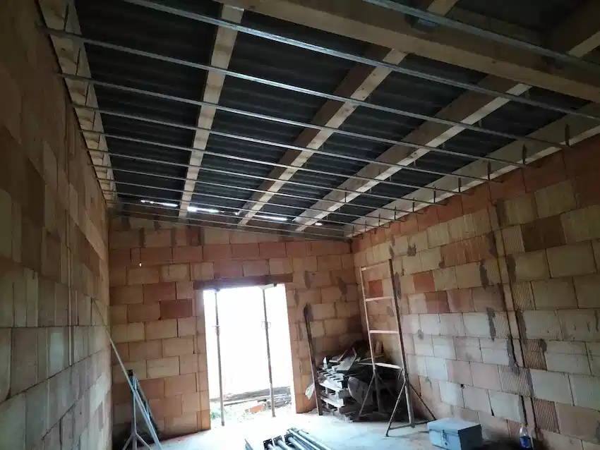 Artisan charpentier réalisant des travaux de charpente sur une toiture